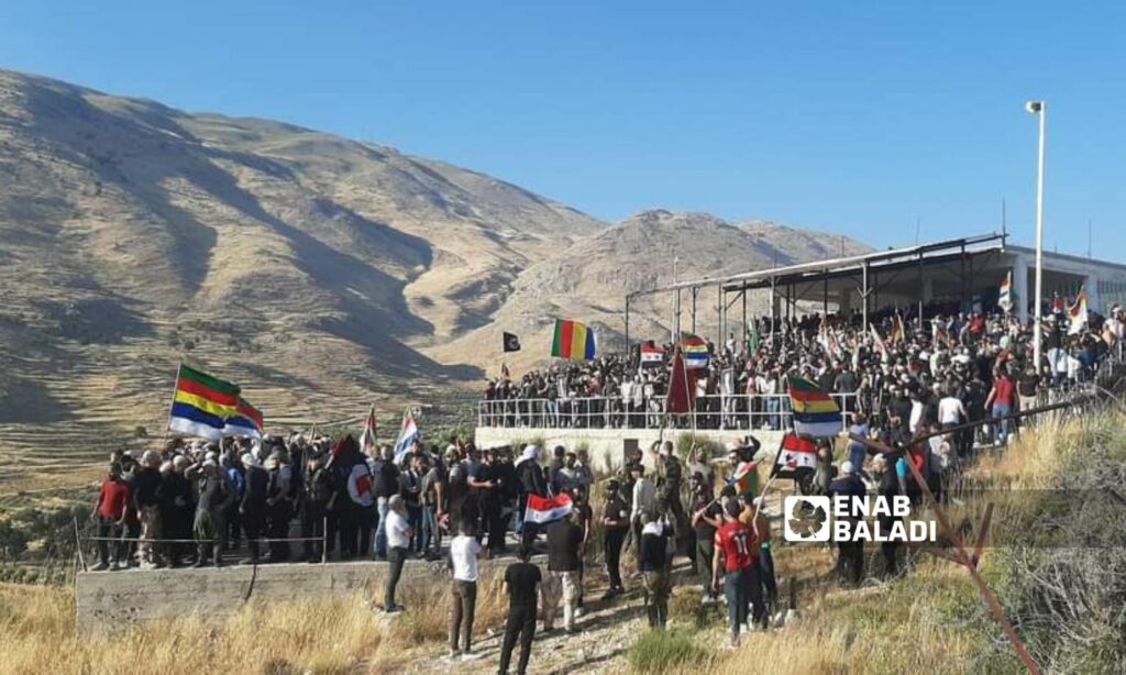 وفد من السويداء وأهالي بلدة عين تينة في وقفة احتجاجية قرب السياج الفاصل بين الأراضي السورية والمحتلة رفضًا لمشروع "التوربينات" الذي يعمل عليه الاحتلال الإسرائيلي - 21 من حزيران 2023 (زين الجولاني /)