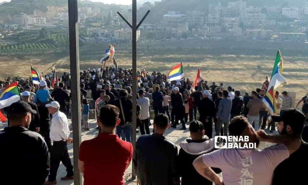 وفد من السويداء وأهالي بلدة عين تينة في وقفة احتجاجية قرب السياج الفاصل بين الأراضي السورية والمحتلة رفضًا لمشروع "التوربينات" الذي يعمل عليه الاحتلال الإسرائيلي - 21 من حزيران 2023 (زين الجولاني /)