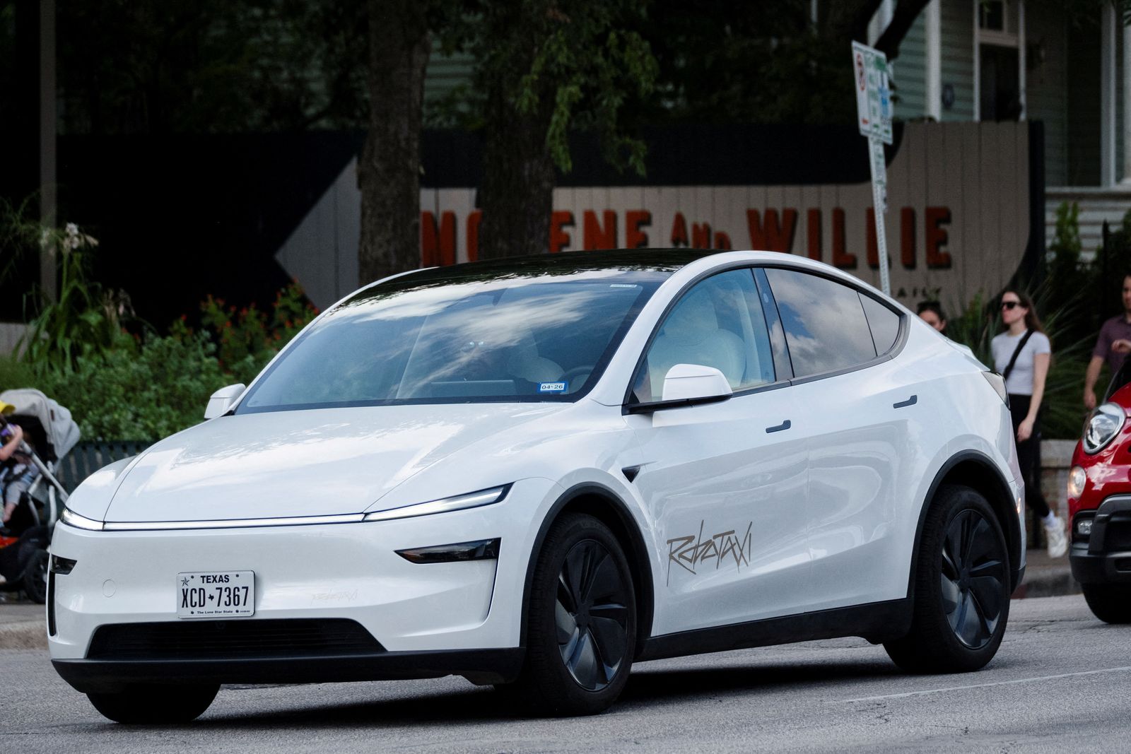 FILE PHOTO: A Tesla robotaxi drives on the street along South Congress Avenue in Austin, Texas, U.S., June 22, 2025. REUTERS/Joel Angel Juarez/File Photo