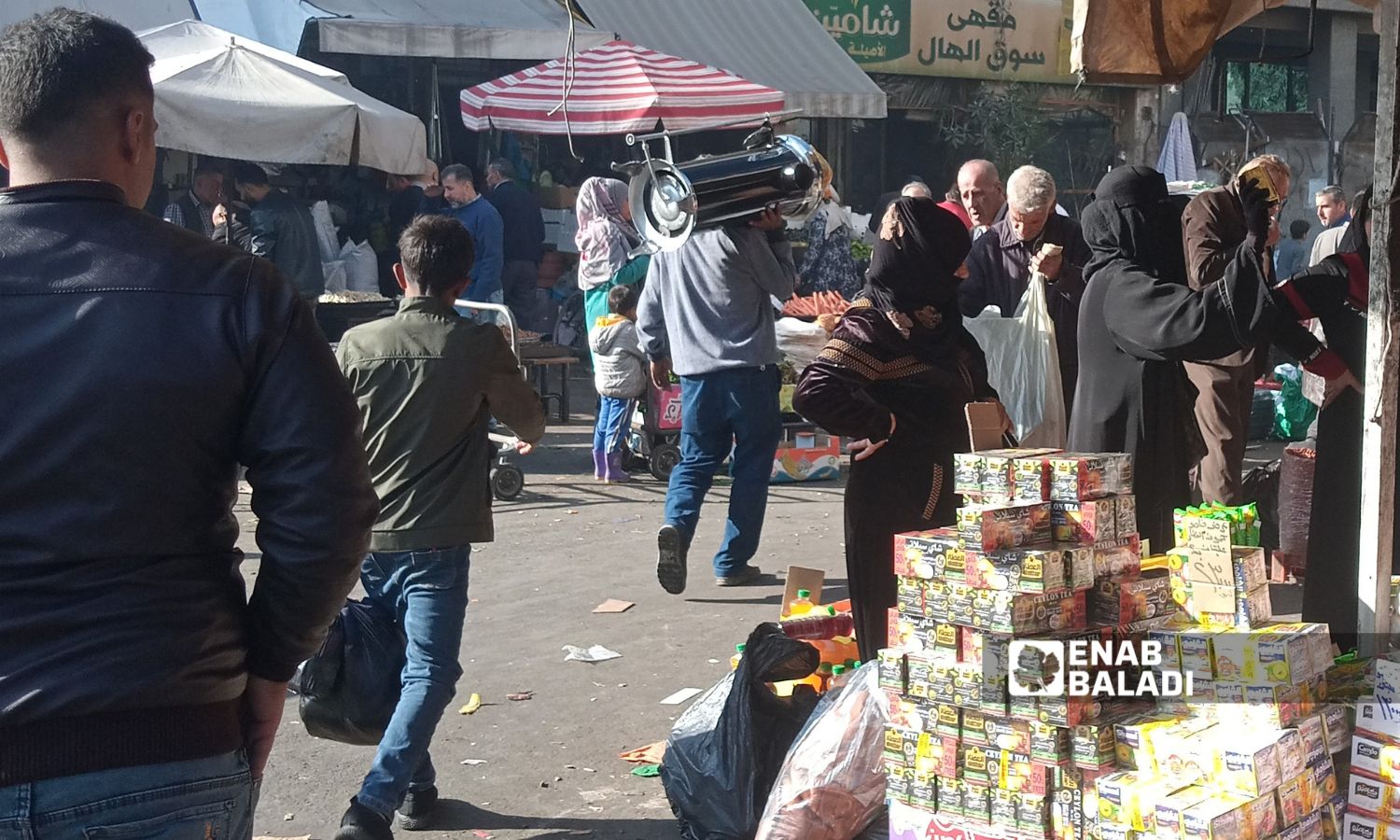 مواطن يحمل مدفئة مازت على كتفه داخل سوق المناخلية - 27 تشرين الثاني 2025 (/مارينا مرهج)