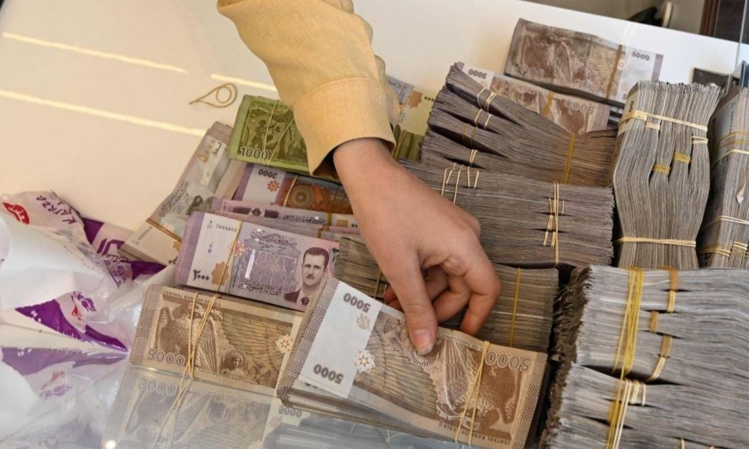 موظف في مكتب صرافة في دمشق - 16 نيسان 2025 (فرانس برس/ لؤي بشارة)