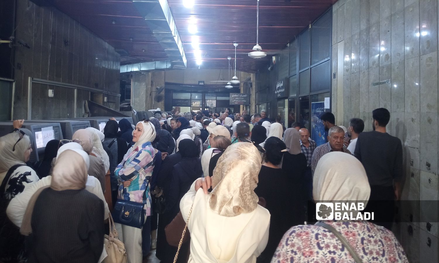 موظفون يقفون في طوابير للحصول على رواتبهم من خلال الصرافات الآلية في صالة الإدارة العامة للمصرف العقاري بدمشق - 12 تشرين الأول 2025 (/مارينا مرهج) 