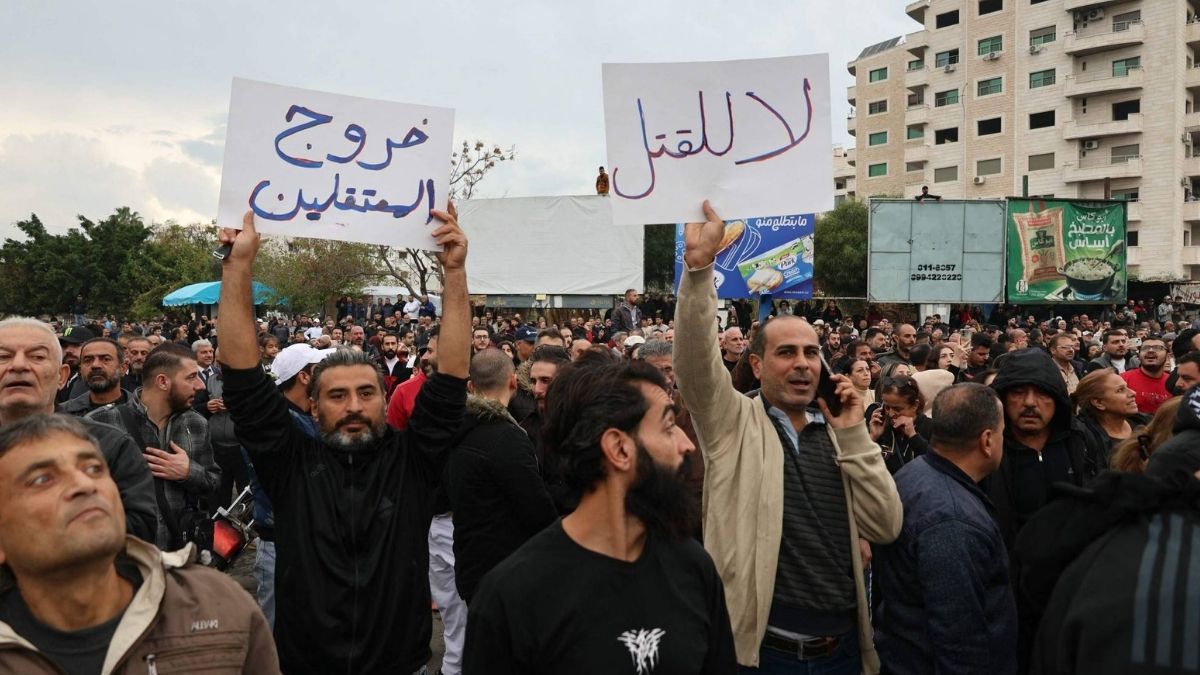 متظاهرون من أبناء الطائفة العلوية في دوار الأزهري وسط مدينة اللاذقية - 25 تشرين الثاني 2025 (AFP)